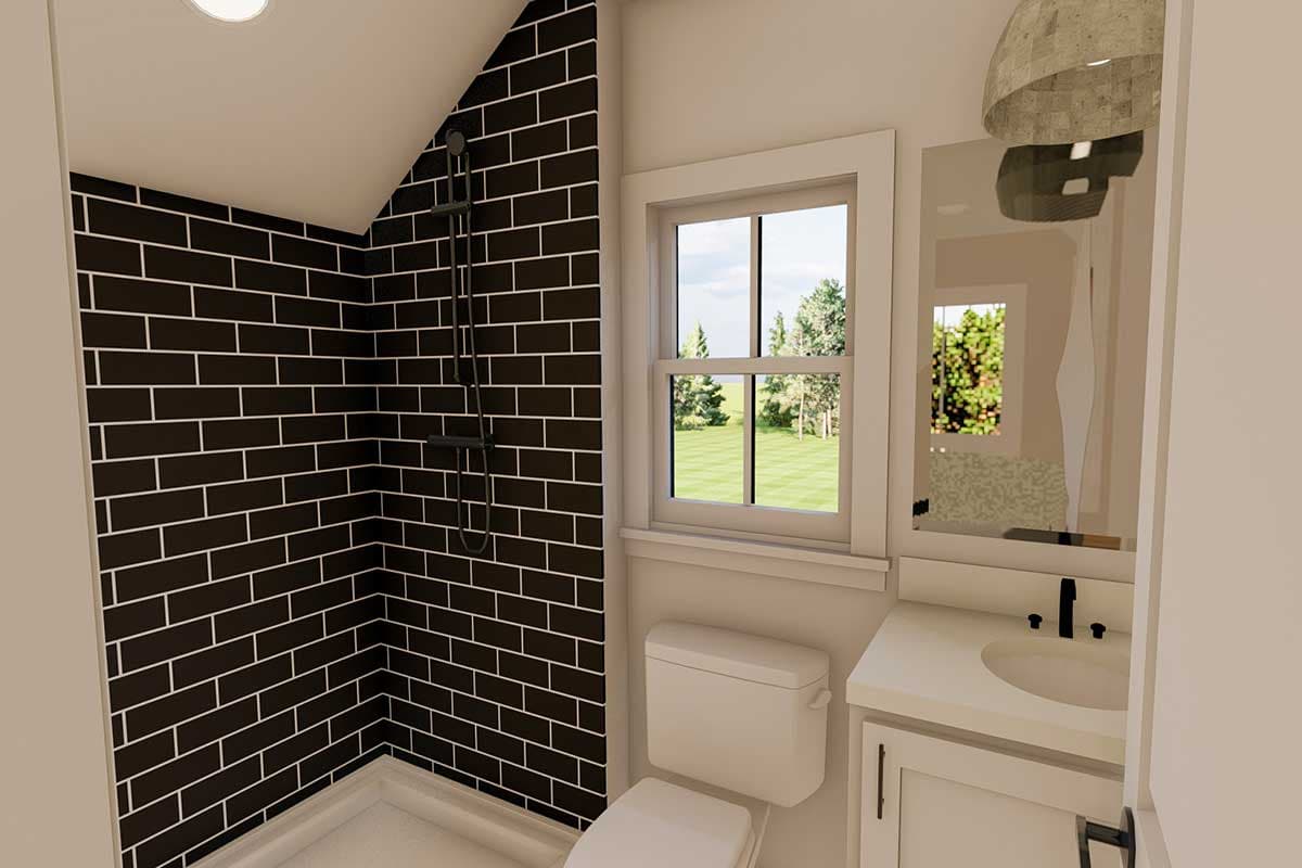 Bathroom with black subway tile shower, white toilet, vanity, and window overlooking a grassy yard.