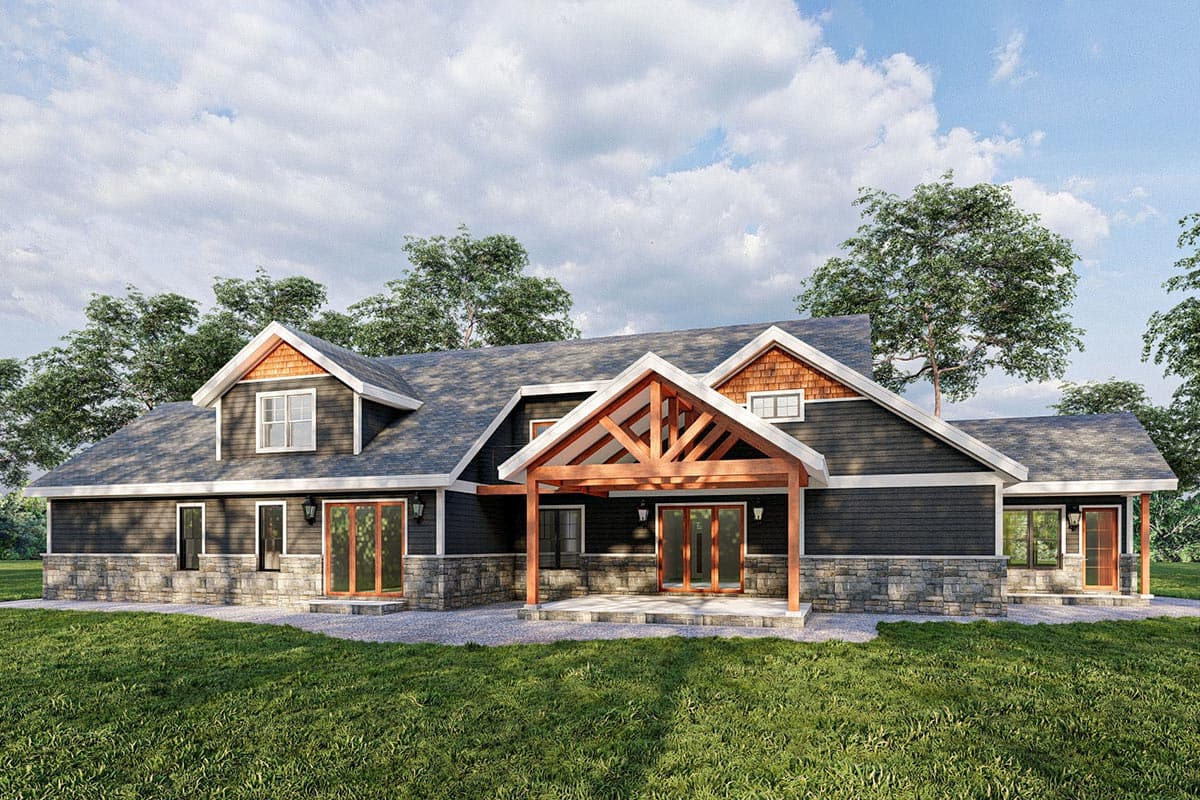 House plan exterior with stone foundation, dark siding, prominent rooflines, dormers, and exposed rafter porch.