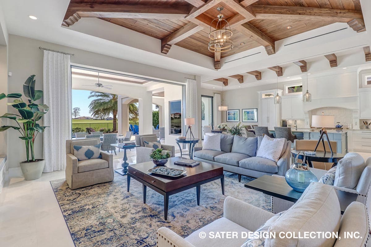 Open-concept living area with coffered wood ceiling, built-in seating, and sliding glass doors opening to a lanai.