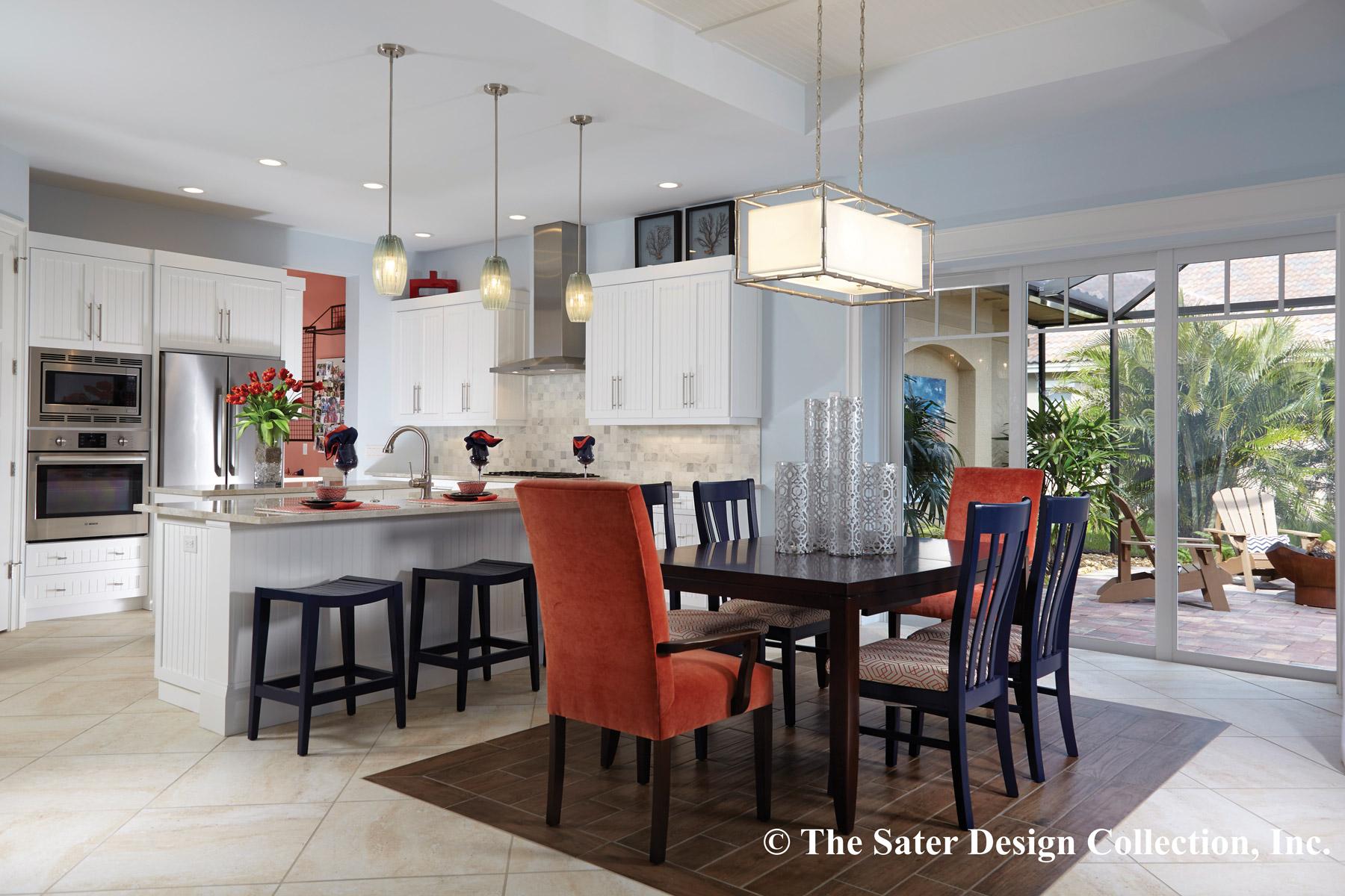 Open-concept kitchen and dining area with white cabinets, island with seating, and sliding glass doors to a patio.