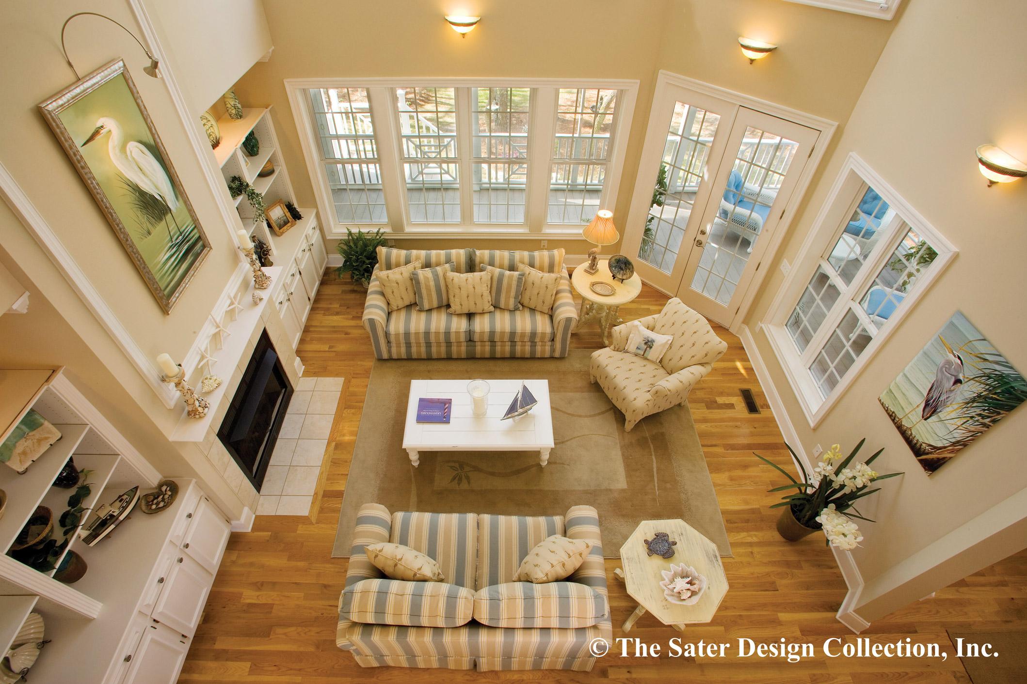 Interior view of great room with vaulted ceiling, fireplace, built-in shelving, and multiple windows.
