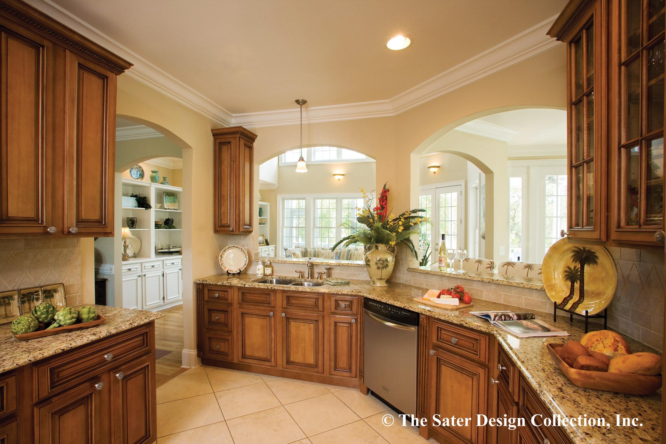 Kitchen with wood cabinetry, granite countertops, double sink, and arched pass-through to dining area with large windows.