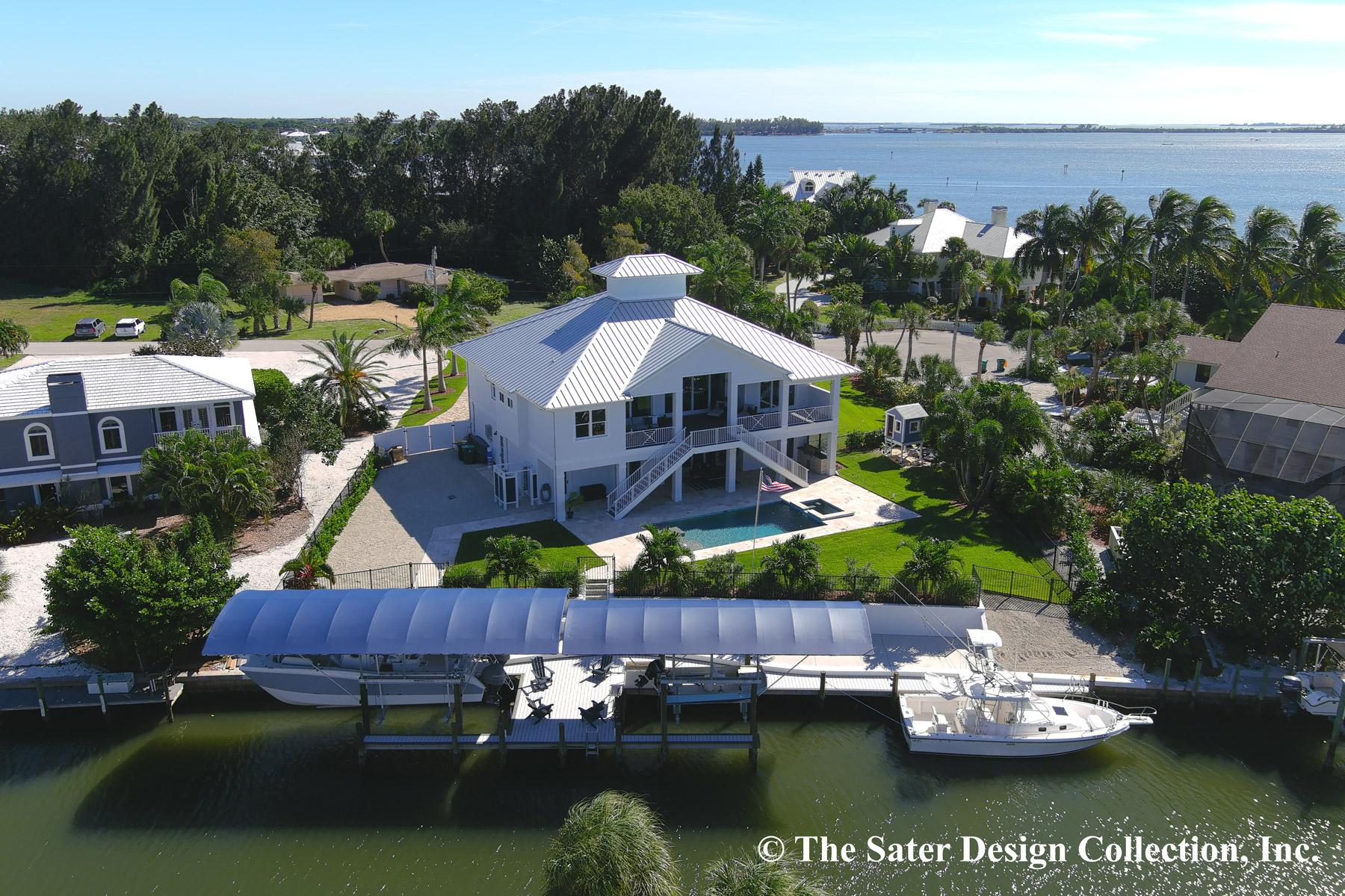 Modern coastal house plan exterior with metal roof, second-story balconies, elevated pool, and private boat dock.