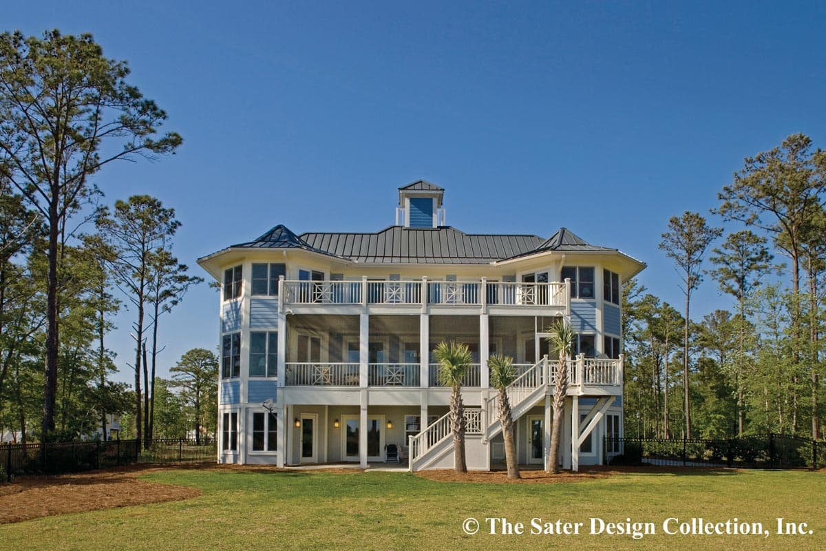House plan exterior: Light blue, multi-story coastal home with wraparound decks, metal roof, and prominent central cupola.