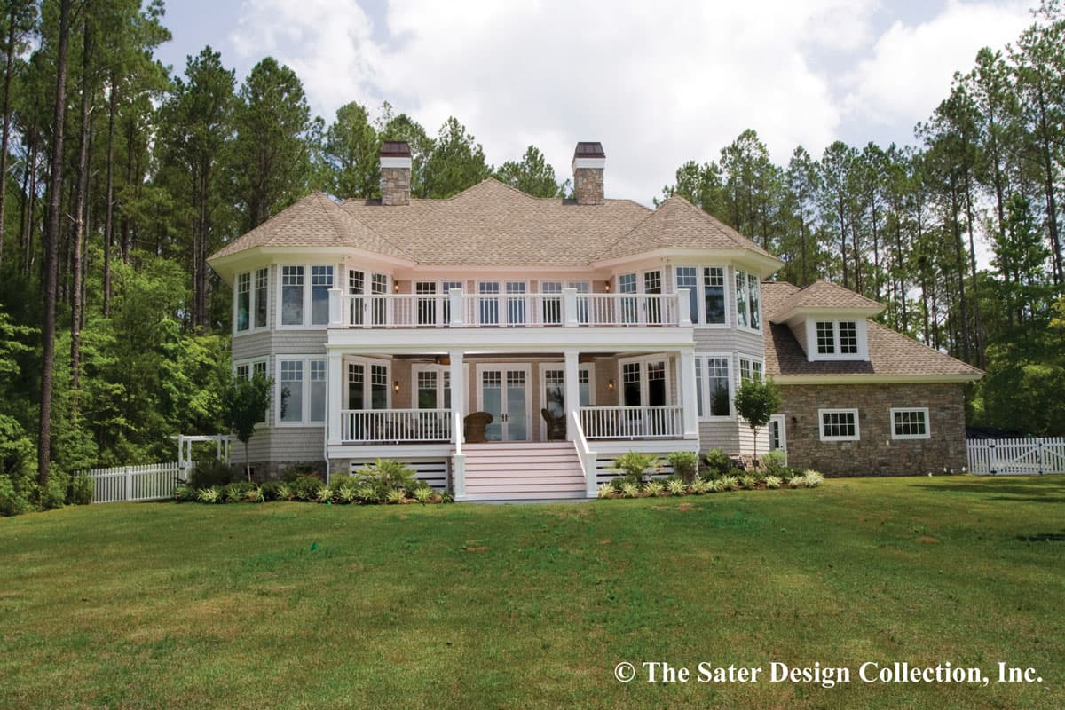 House plan exterior: Two-story home with multiple gables, stone accent on garage, and wraparound second-story balcony.