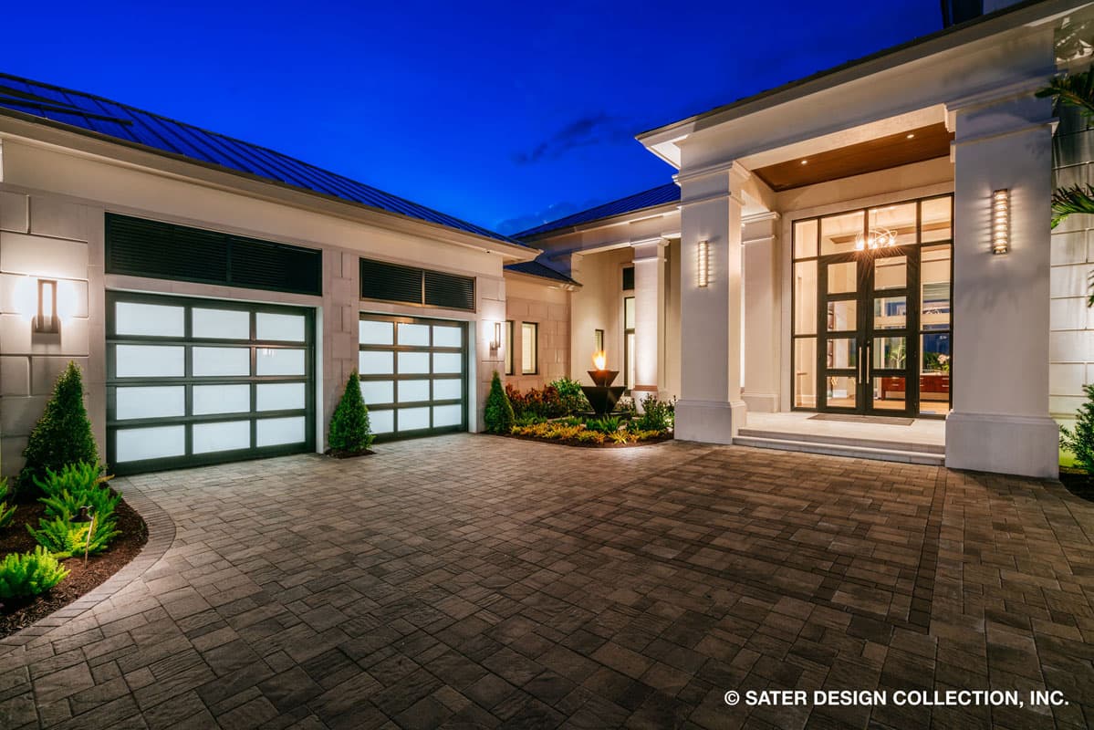 Modern house plan exterior with a wide driveway, double garage doors with frosted glass, and a grand entryway with double doors and tall columns.
