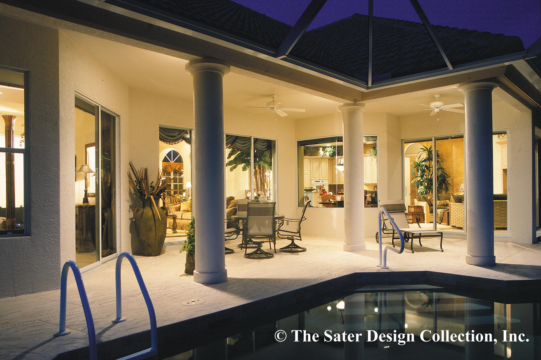 Covered patio with columns, outdoor seating, and a pool, adjacent to a house with large windows revealing interior living spaces.
