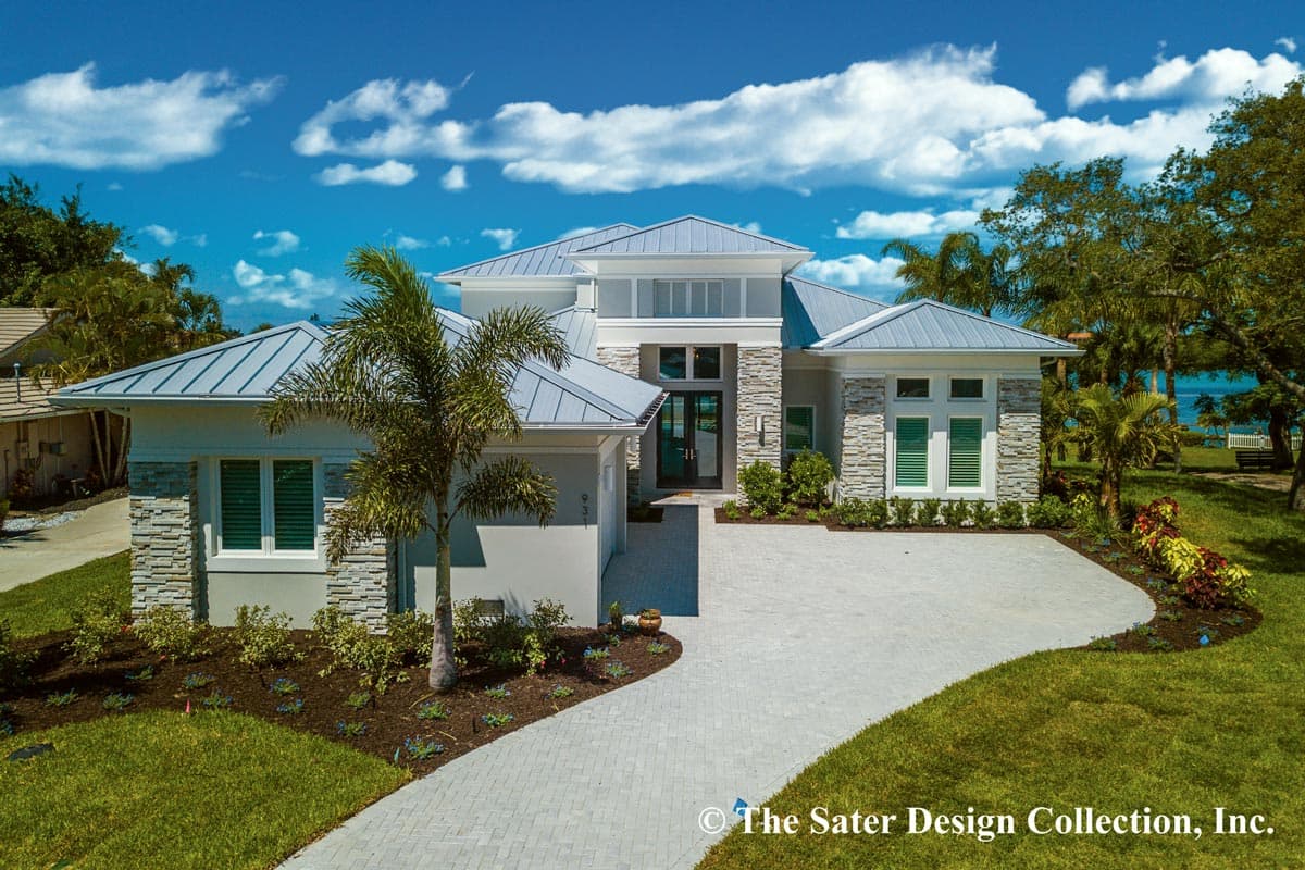 House plan exterior. Two-story home with a metal roof, stone accents, and an attached garage. Features include a covered entry and multiple gables.