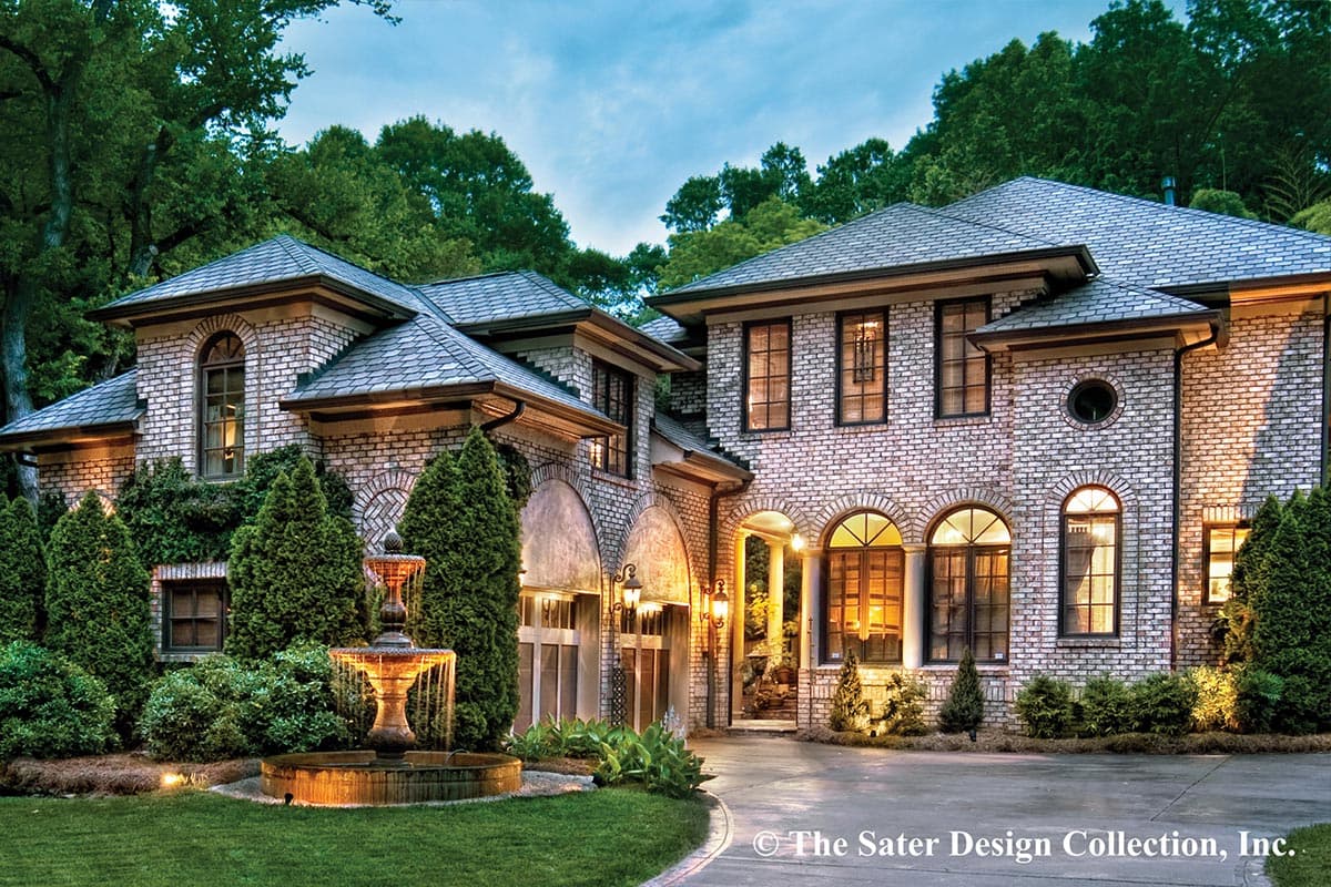 House plan exterior featuring brick facade, multiple gables, arched windows, and a central fountain.