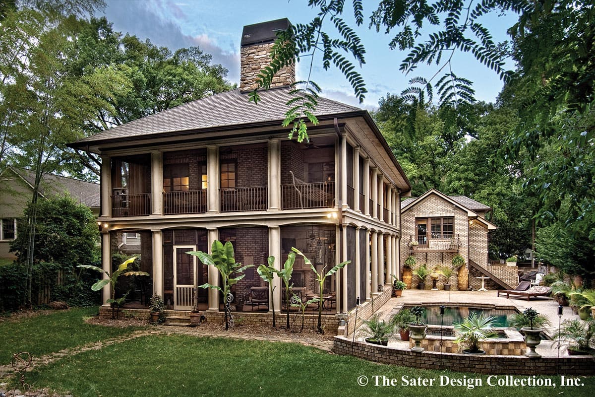 House plan exterior: Two-story brick home with a wraparound screened porch, stone chimney, and multiple balconies.
