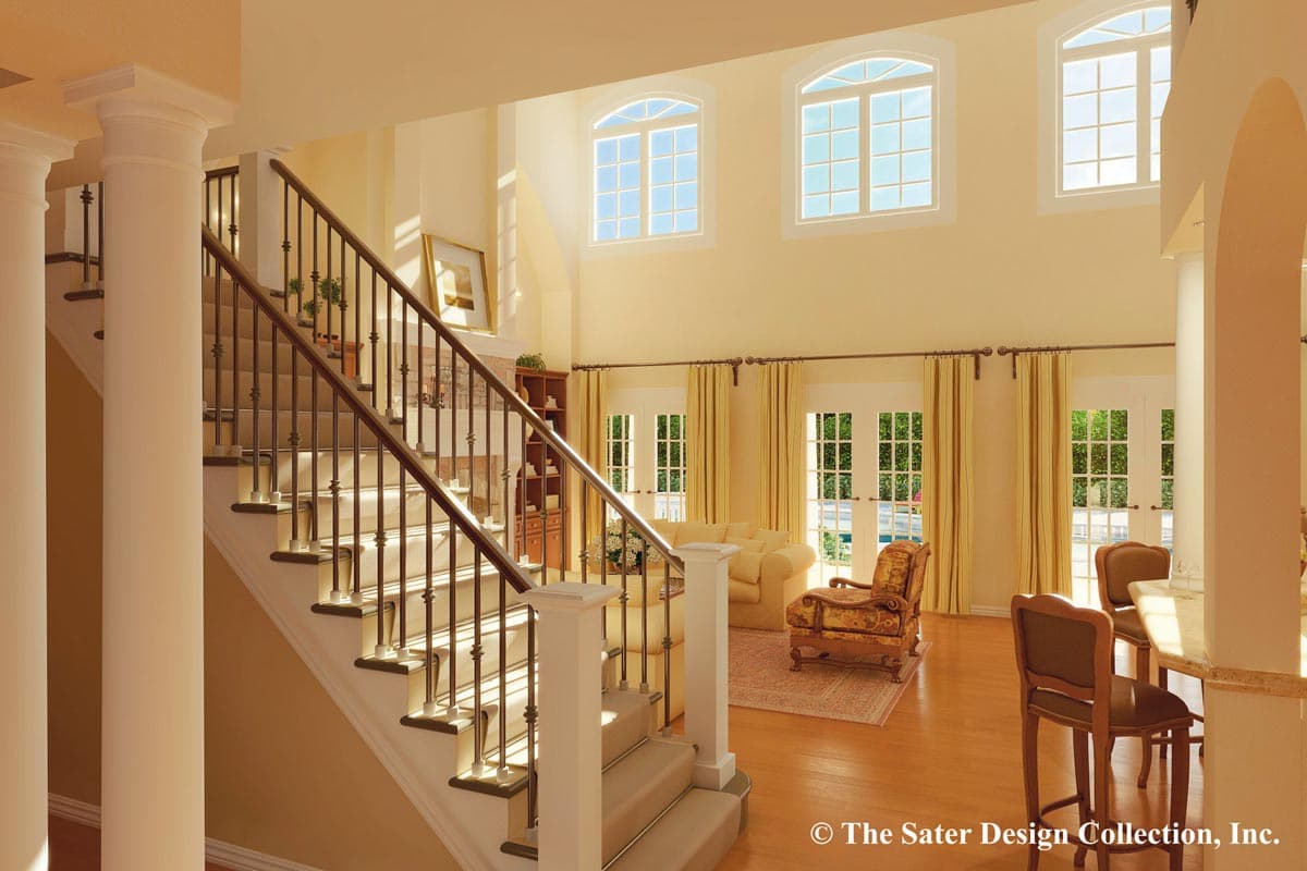 Interior rendering: Grand foyer with curved staircase, tall columns, fireplace, and double doors leading to an outdoor area.
