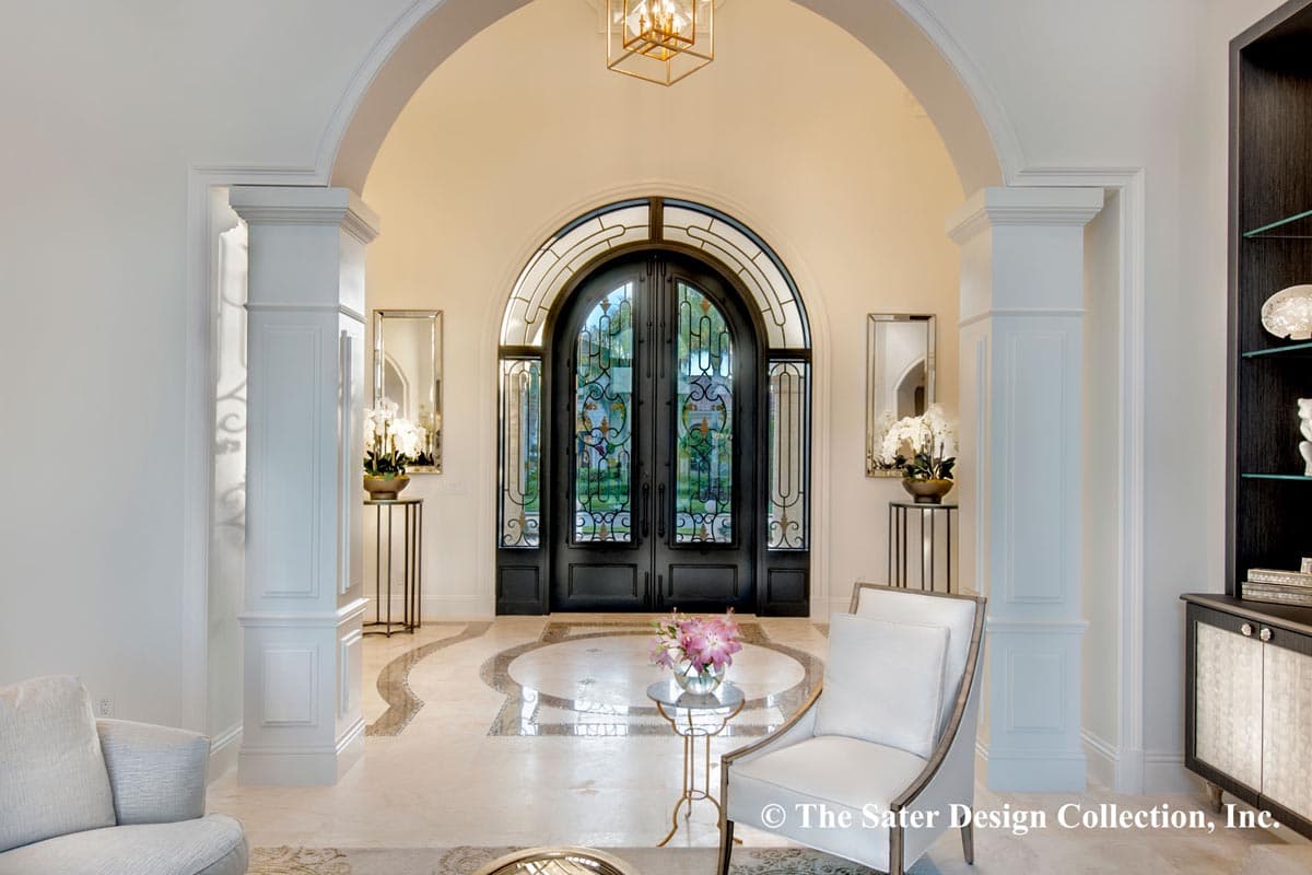 Entrance hall featuring arched entryway with decorative double doors, columns, mirrors, and marble flooring.