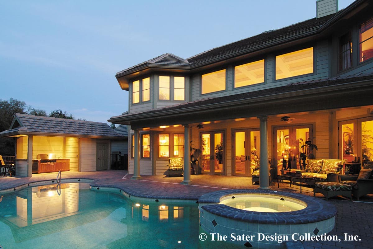 House plan exterior with pool and covered patio. Two-story home features multiple gables, large windows, and an attached outdoor kitchen.