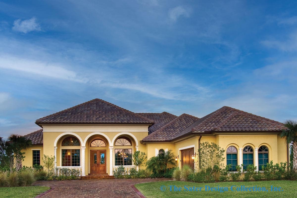 House plan exterior. One-story Mediterranean home with arched entry, tiled roof, and garage on the side of the house.