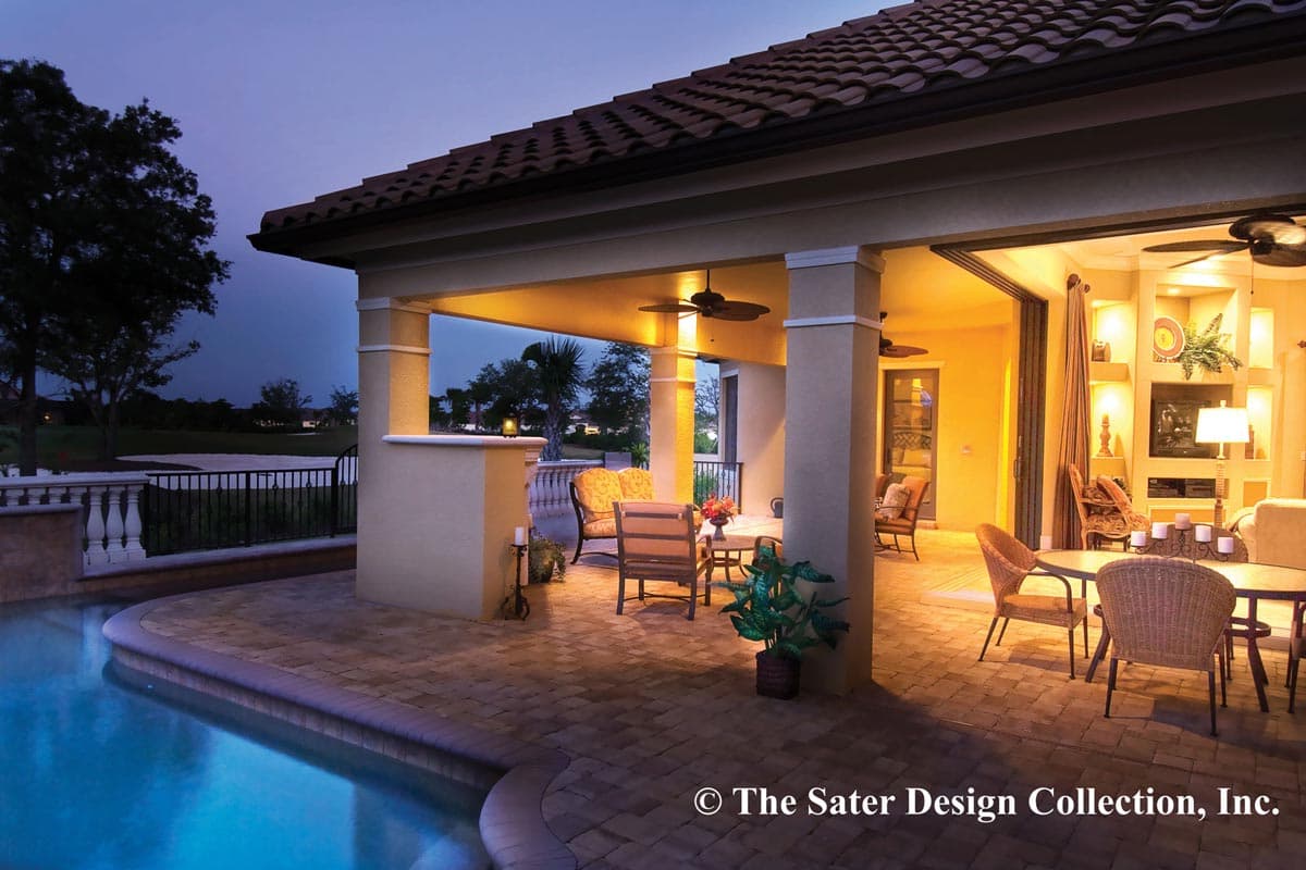 Covered patio with seating and dining areas adjacent to pool. Interior living space visible through open doors.