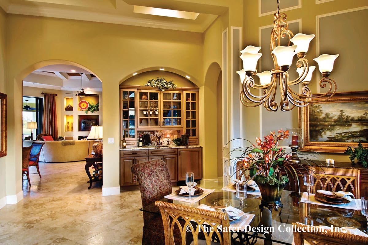 Dining room with built-in cabinetry, chandelier, and view of living area with fireplace.