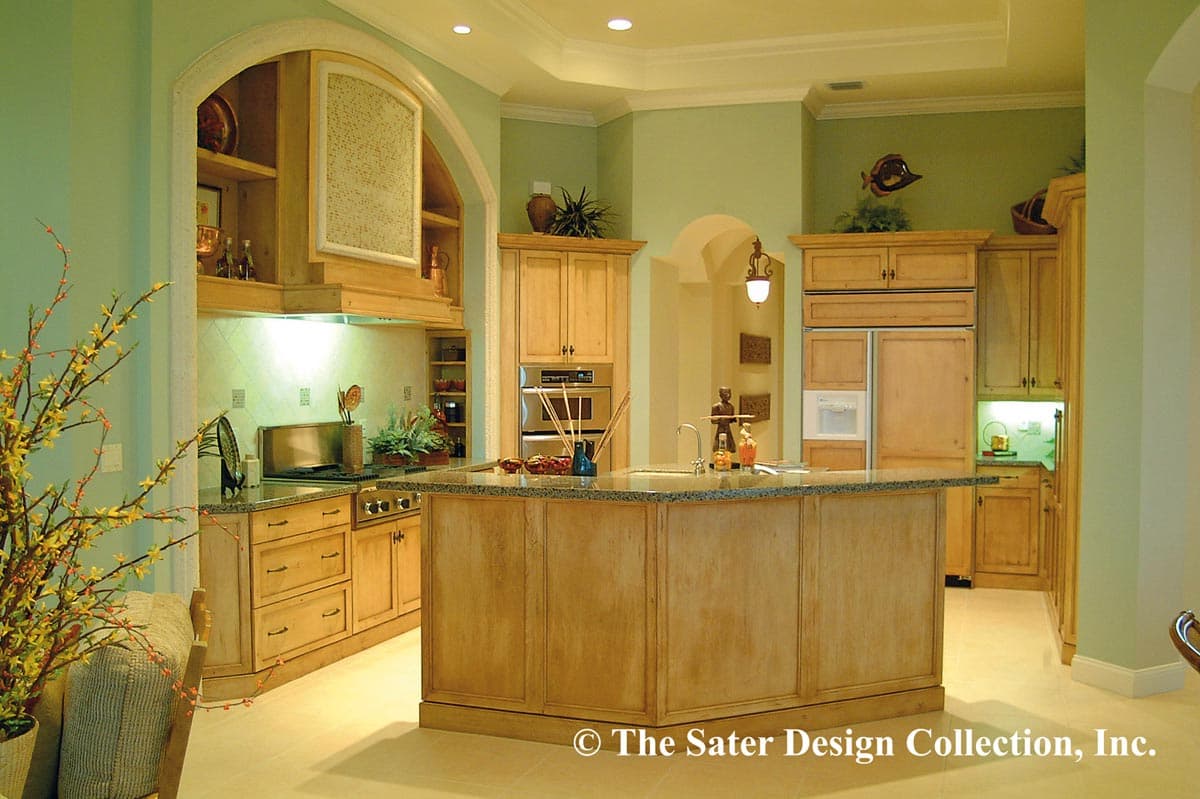 Interior kitchen with large island, built-in oven, range, pantry, and arched hood with shelving.