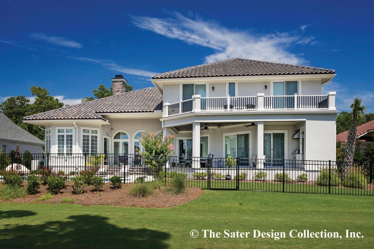 House plan exterior: Two-story stucco home with a tile roof, bay windows, arched windows, and a second-story balcony.