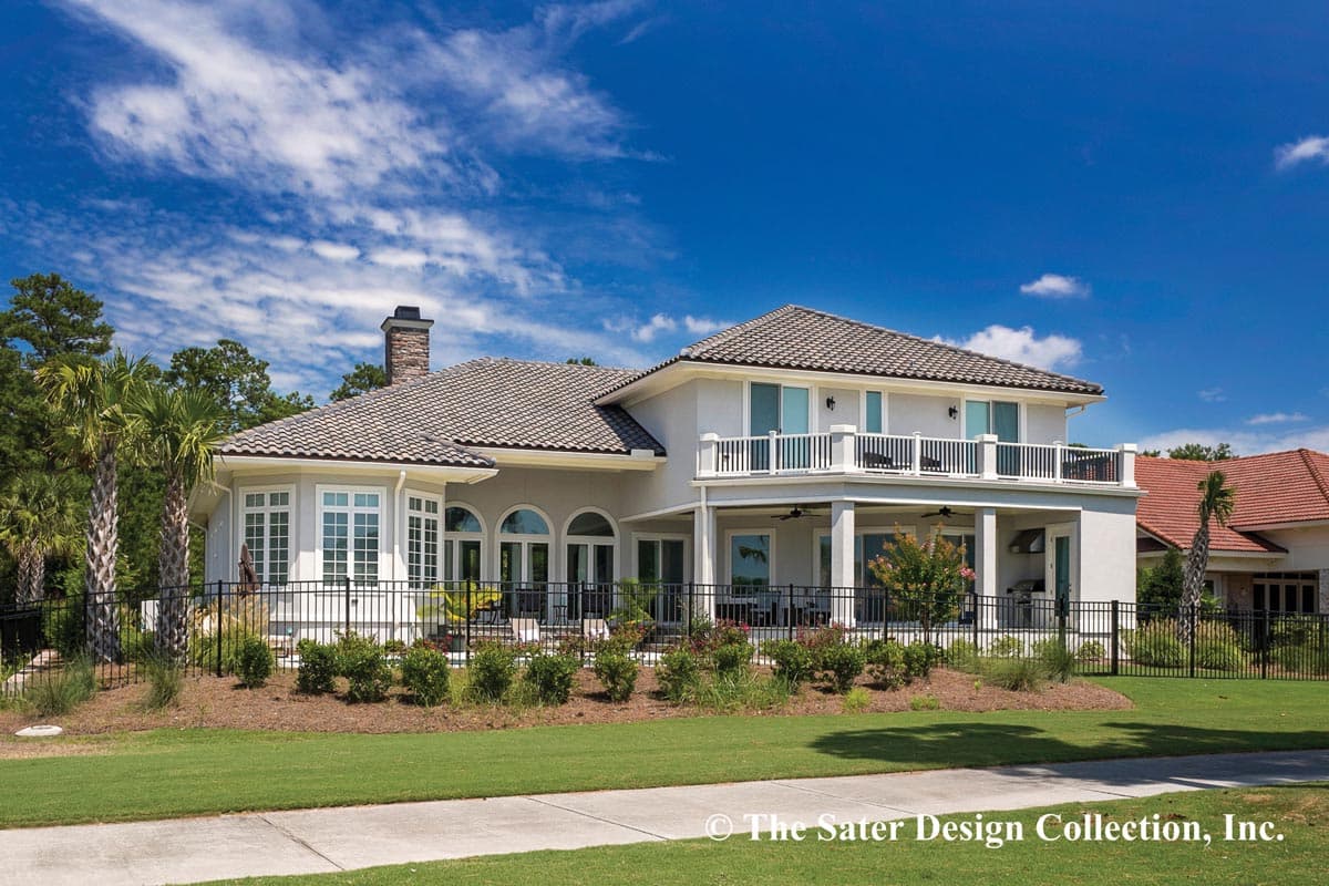 House plan exterior: Two-story stucco home with tile roof, balcony, bay window, and arched French doors.