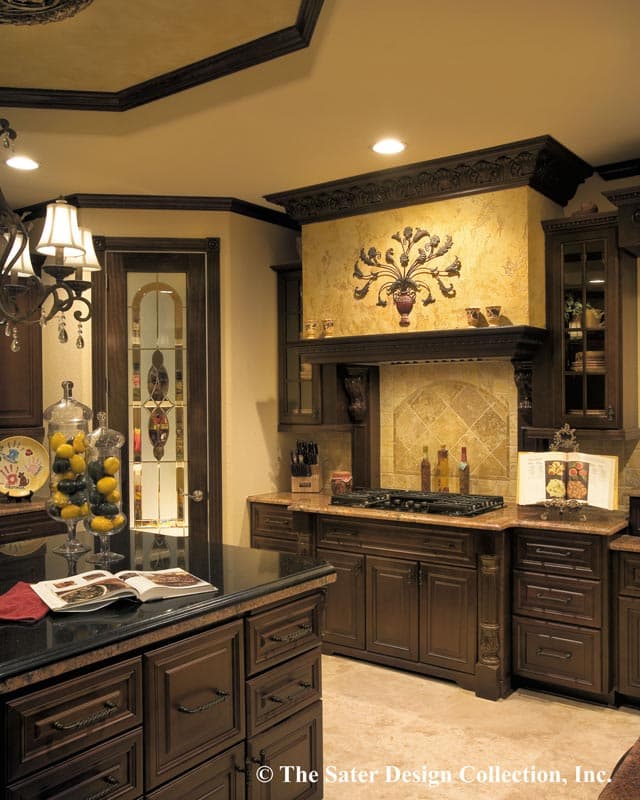 Kitchen with dark wood cabinetry, granite countertops, a decorative range hood with a metal wall art, and a stained-glass door.