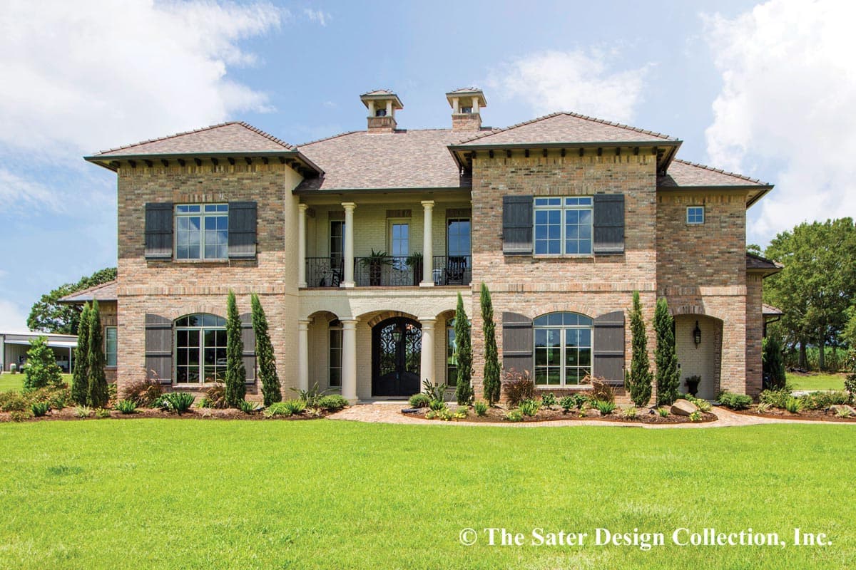 House plan exterior. Two-story brick home with a front porch, multiple gables, and shuttered windows. Features include a symmetrical design.