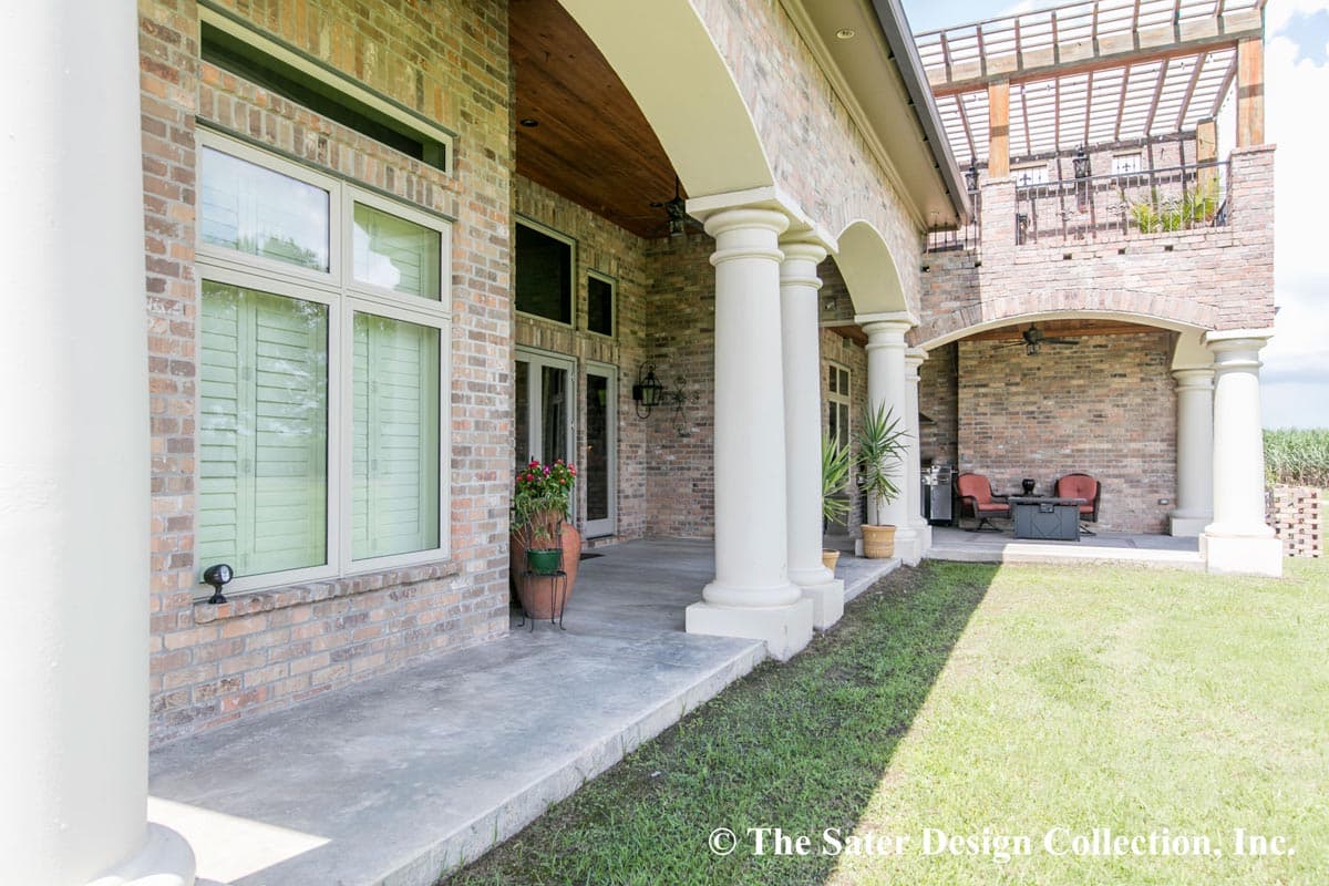 House plan exterior with covered porch supported by columns, arched openings, and a pergola above.