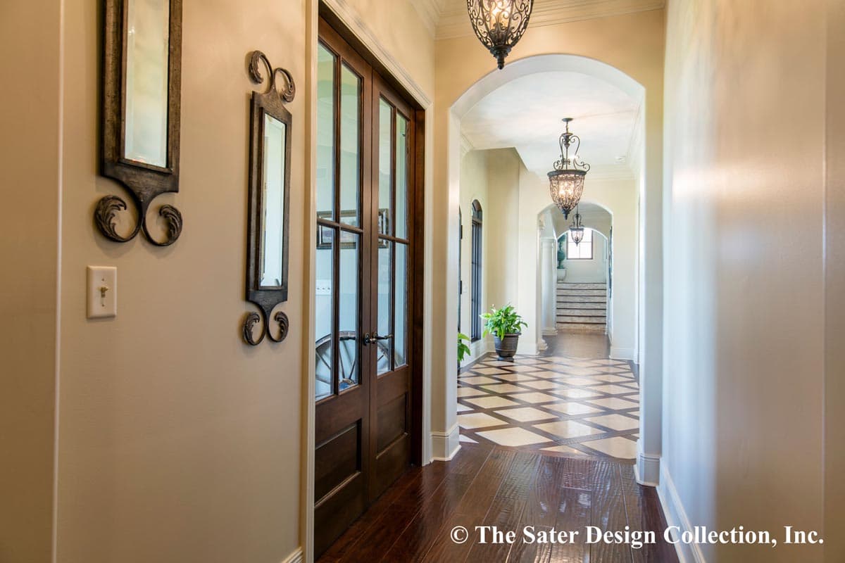 Hallway interior with wood-paneled glass doors, patterned floor, arched doorways, and decorative lighting.