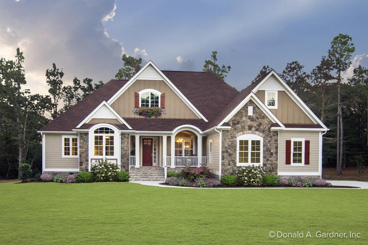 House plan exterior with stone accents, gabled roof, and a front porch. Features include arched windows and decorative shutters.