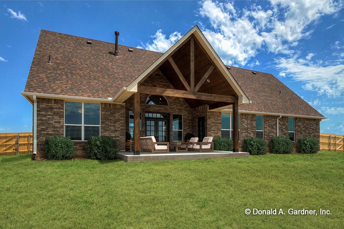 House plan exterior: One-story brick home with prominent gabled covered patio featuring exposed timber framing and double doors.