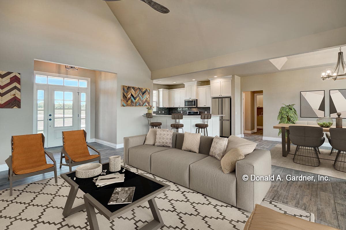 Open concept living area with vaulted ceiling, showing entry, kitchen with island, and dining area.