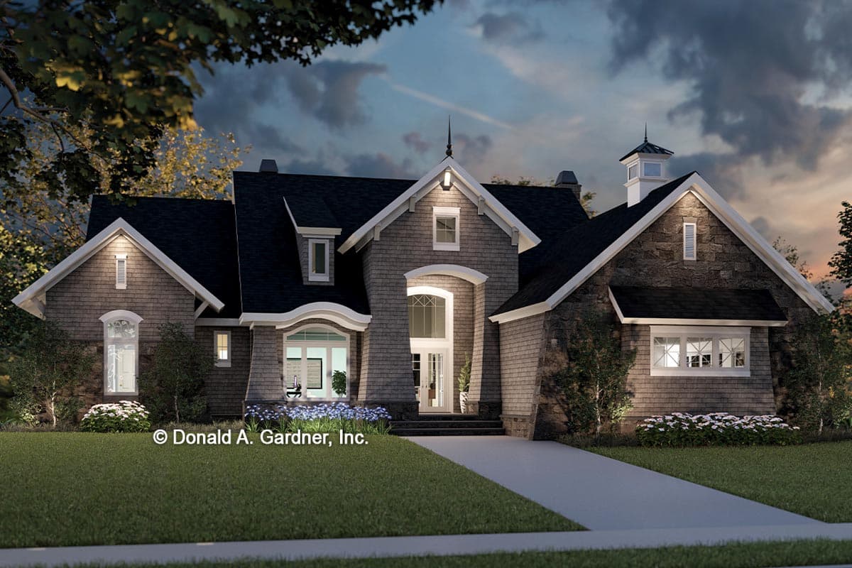 House plan exterior: Two-story home with steep gables, dormers, arched entrance, and stone and shingle facade.