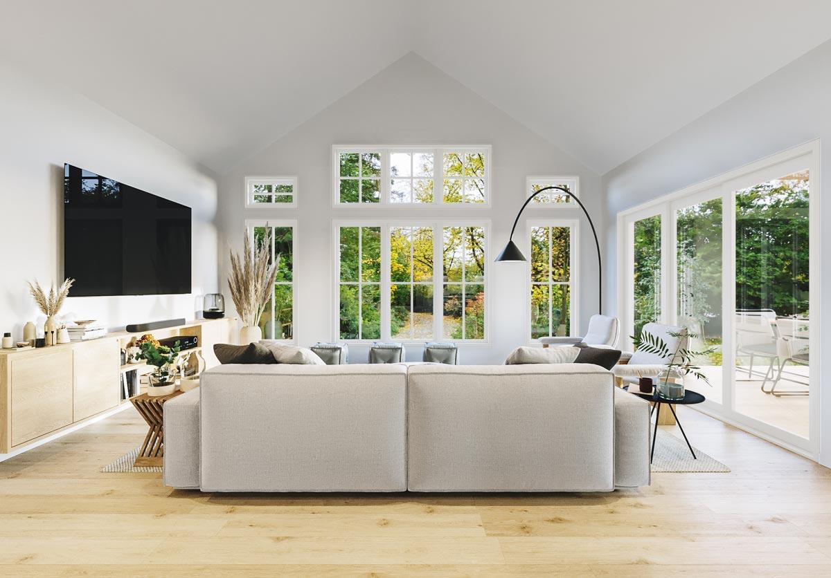 Interior rendering of a great room with vaulted ceiling, large windows, and open layout looking toward a patio.