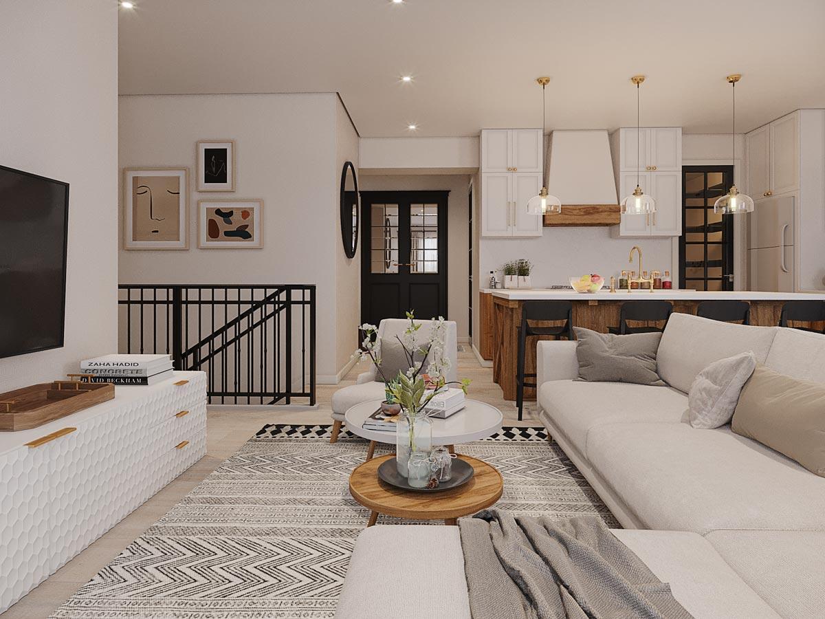Open-concept living area with sectional sofa, kitchen island with bar stools, and a staircase with black railing.