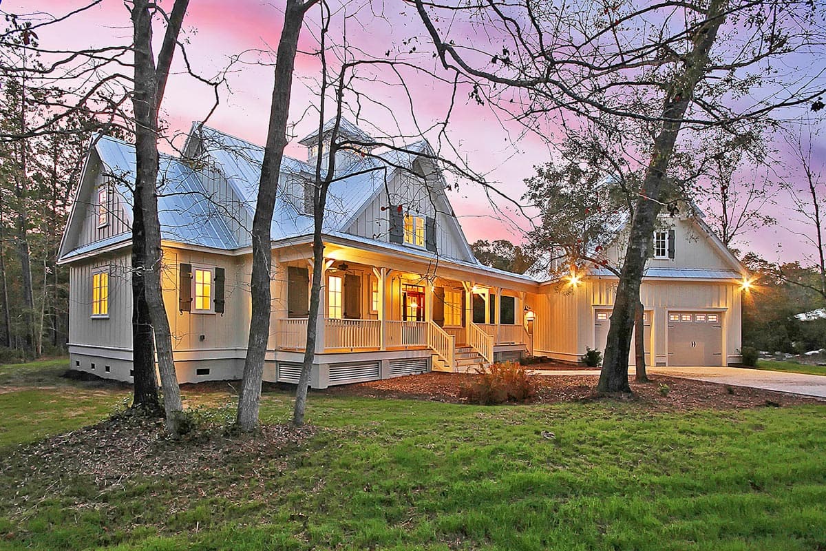 House plan exterior: Craftsman style, two stories, wrap-around porch, metal roof, and attached two-car garage.