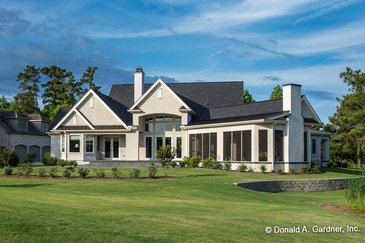 House plan exterior showcasing a stucco finish, gabled rooflines, a screened porch, and a large arched window array.