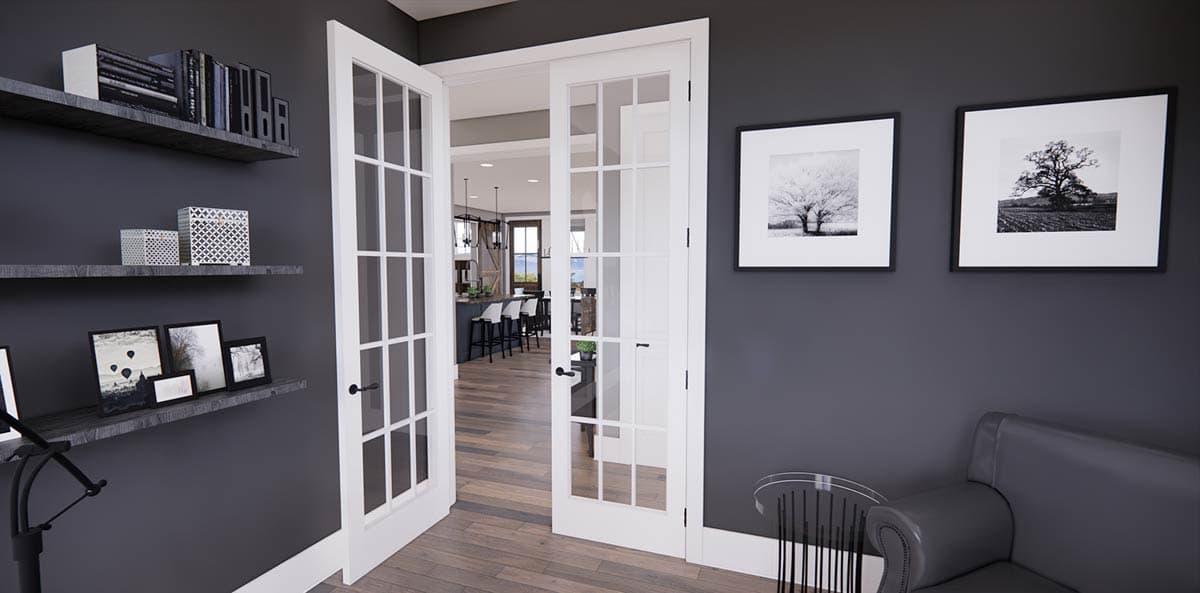 Interior shot featuring open French doors leading to a kitchen with bar seating, framed black and white art, and a small sofa.