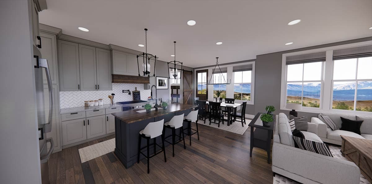 Spacious, modern kitchen and dining area featuring a large island with bar stools, dark wood floors, and views of a mountain landscape.