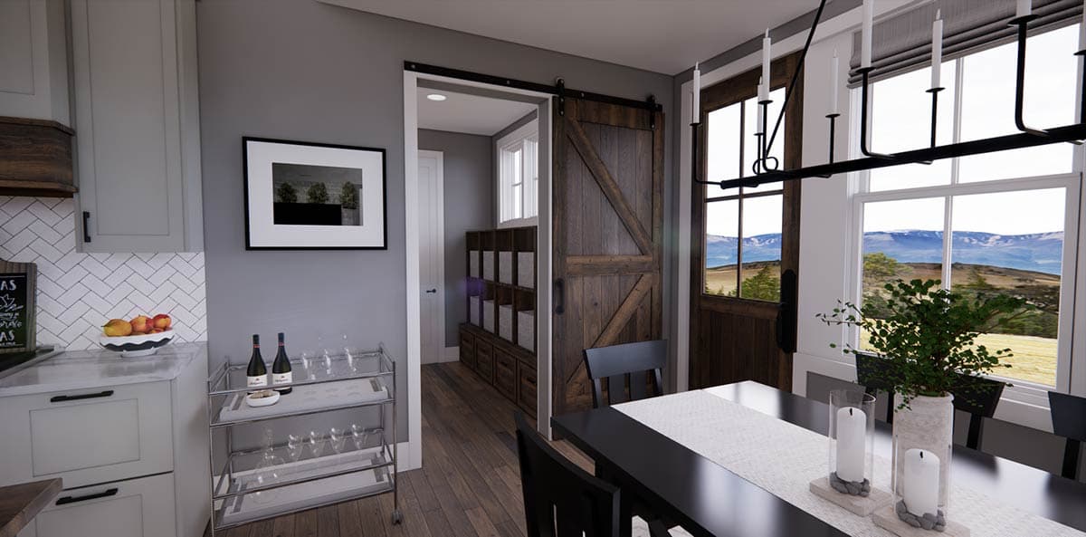 Interior shot of a dining area with a modern farmhouse design. Features a sliding barn door, black dining table, and large windows with a scenic view.