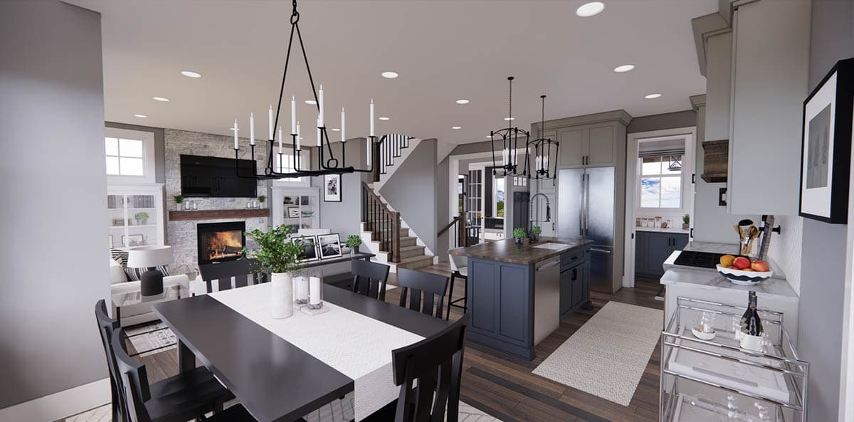 A modern, open-plan living and kitchen area with a fireplace, dining table, and island. A staircase leads up to a second floor.