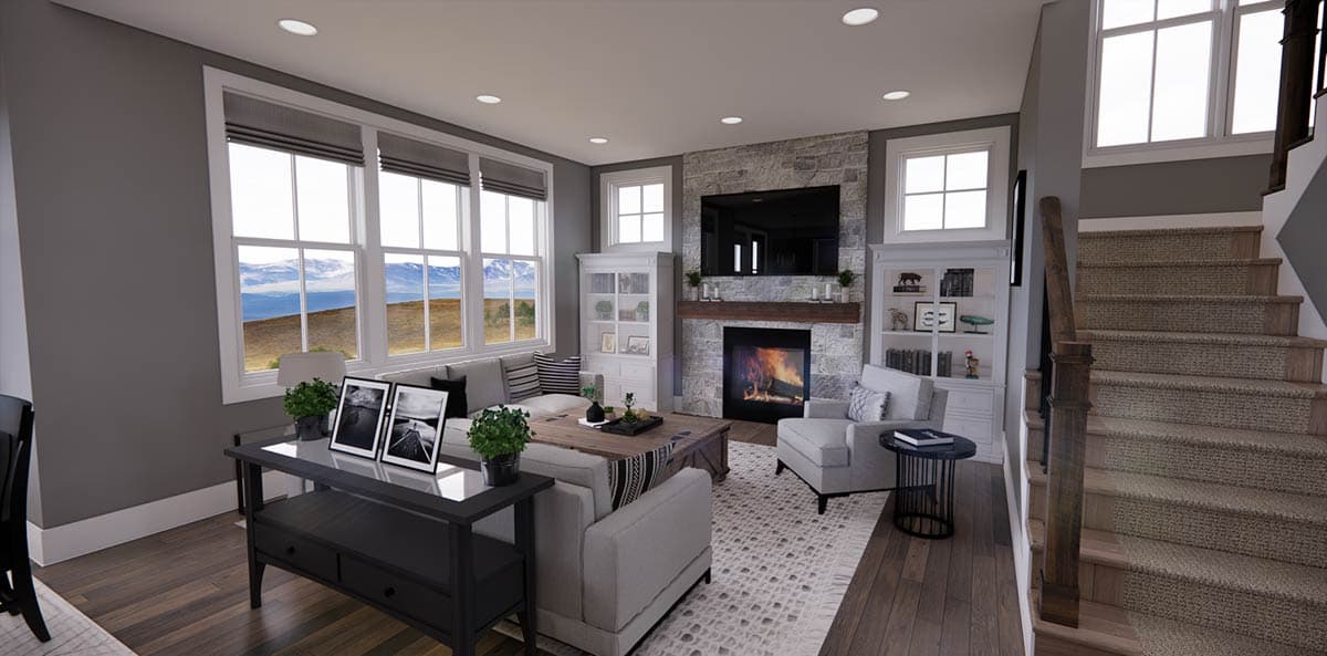 Cozy living room interior with a fireplace, a large window showcasing a mountain view, and a staircase leading to the upper level.