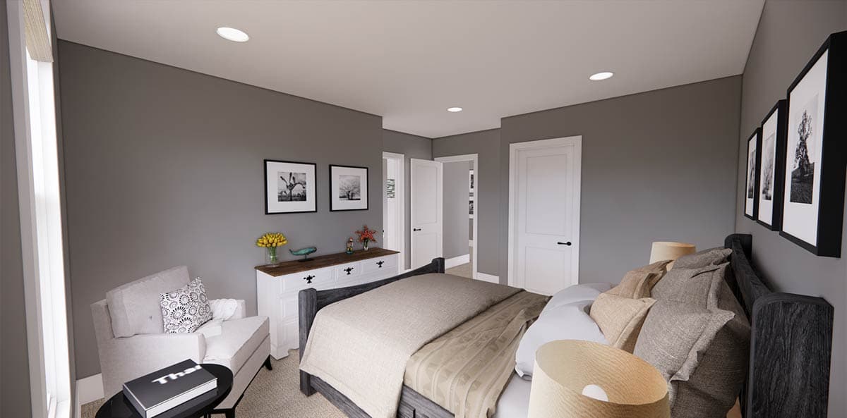Spacious bedroom with gray walls, a large bed, and a white dresser. Artwork hangs above the dresser and near the bed, with a side chair visible.