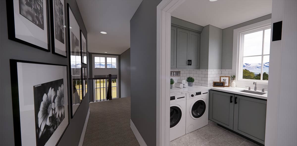 A hallway with a series of framed black and white floral prints leads to a laundry room with a window overlooking mountains.