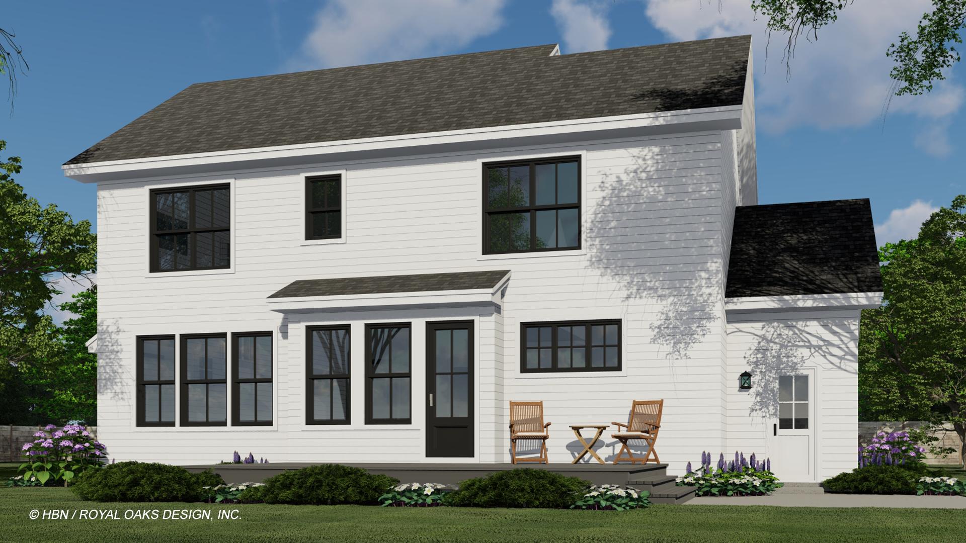 A two-story white house with black window frames and a dark door. Two chairs and a small table sit on a porch area. Landscaping and a blue sky.