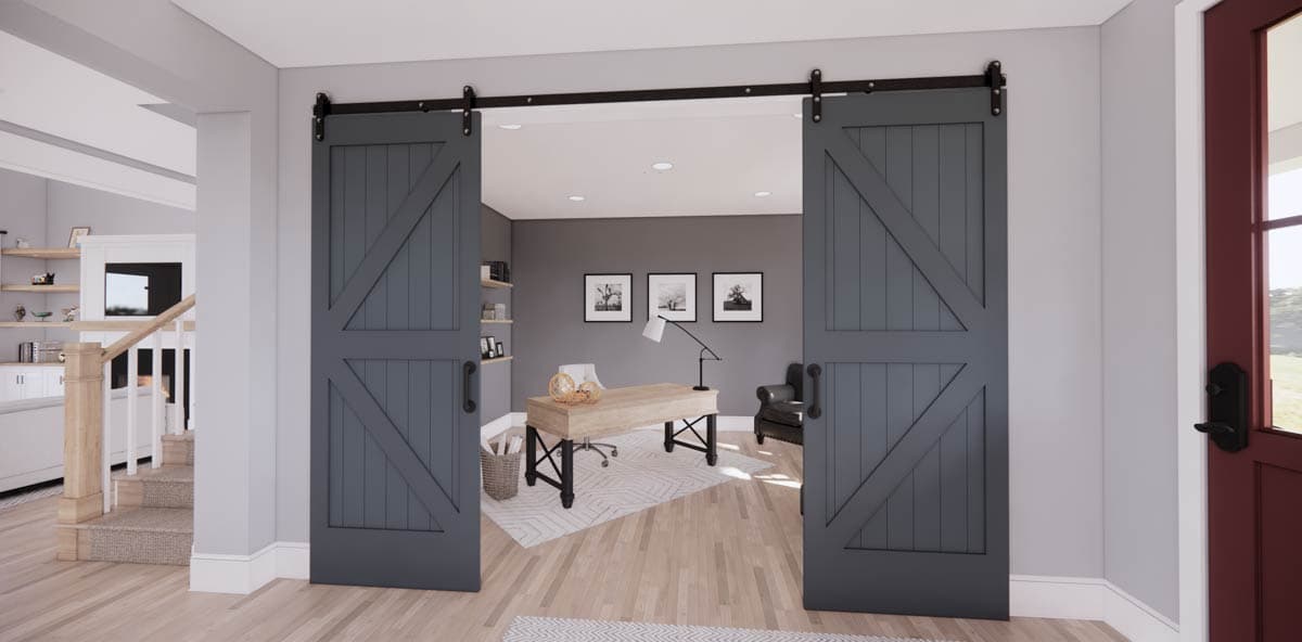 A home office is visible through barn-style, gray sliding doors. The office includes a desk, chair, and black-framed art on the wall.