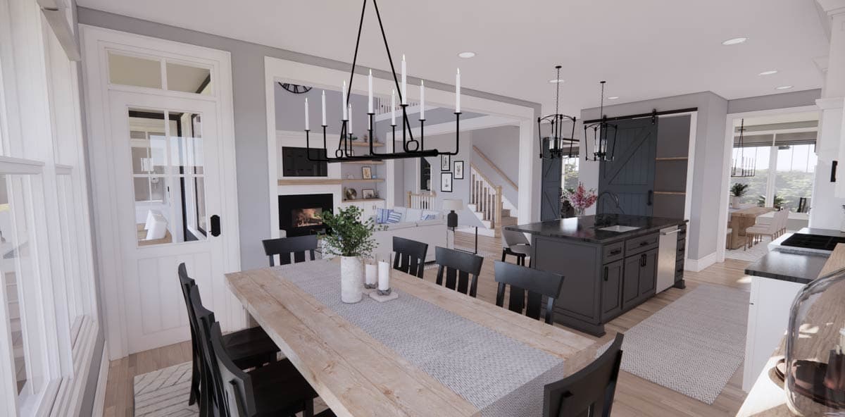 Spacious, modern kitchen and dining area featuring a long wooden table with black chairs, leading into a living room with fireplace.