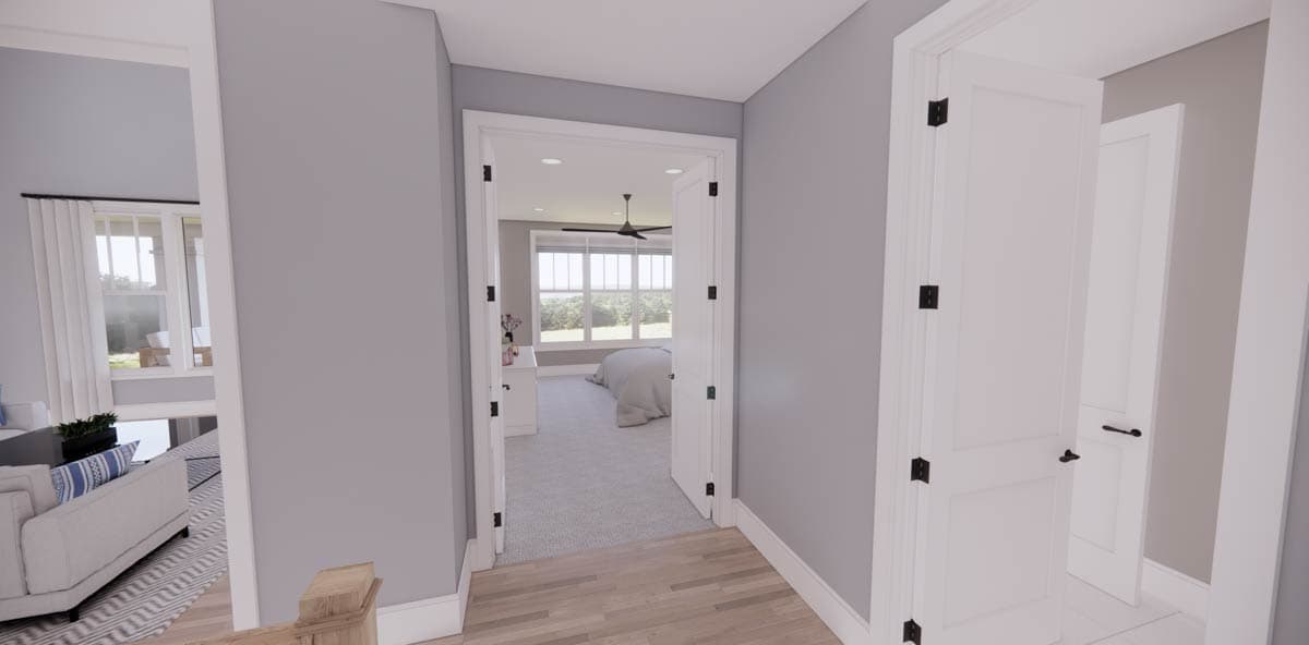 A hallway leads to a bedroom with a bed and natural light. White doors with black hardware line the hallway with grey walls.