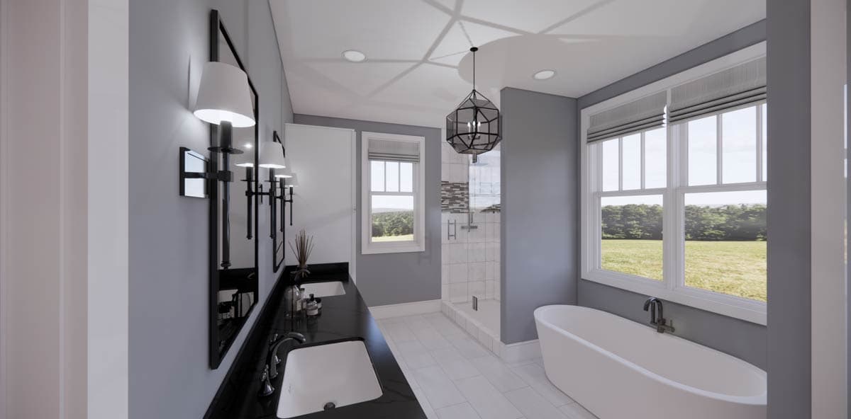A modern bathroom features a sleek black countertop with two sinks and a freestanding white bathtub next to large windows overlooking a field.