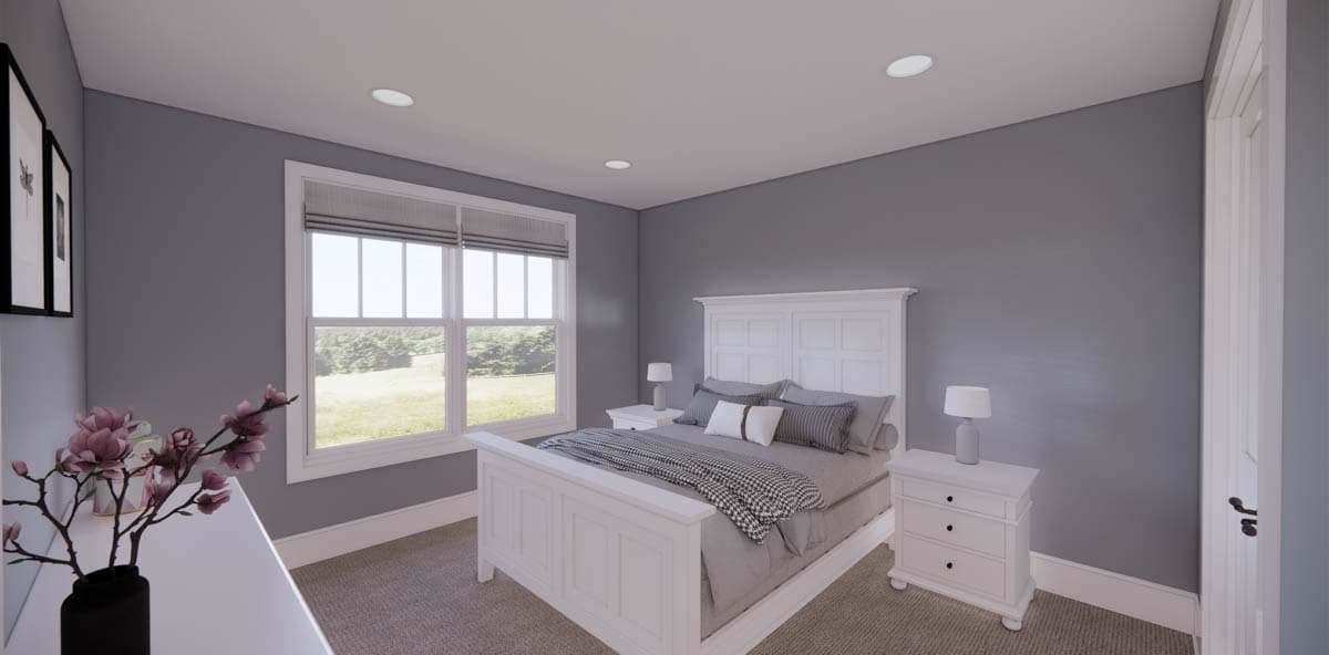 A modern bedroom with a white bed frame and matching nightstands. Large window reveals a view of a grassy landscape. Decorative flower arrangement.