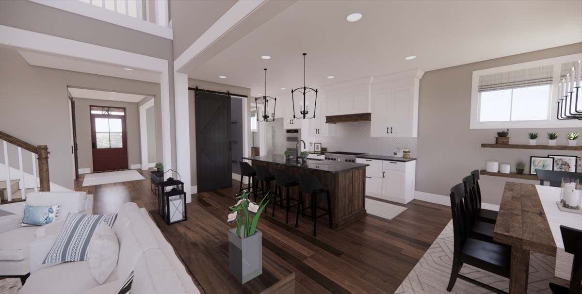 A modern, open-concept home interior with a kitchen island, dining area, and living space. Dark wood floors and white cabinets provide contrast.