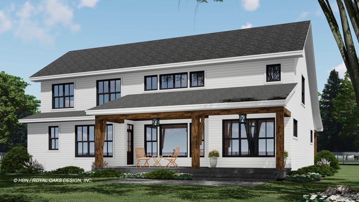 A modern, two-story farmhouse design with white siding, black-framed windows, and a covered porch with wooden beams. Two chairs sit on the porch.